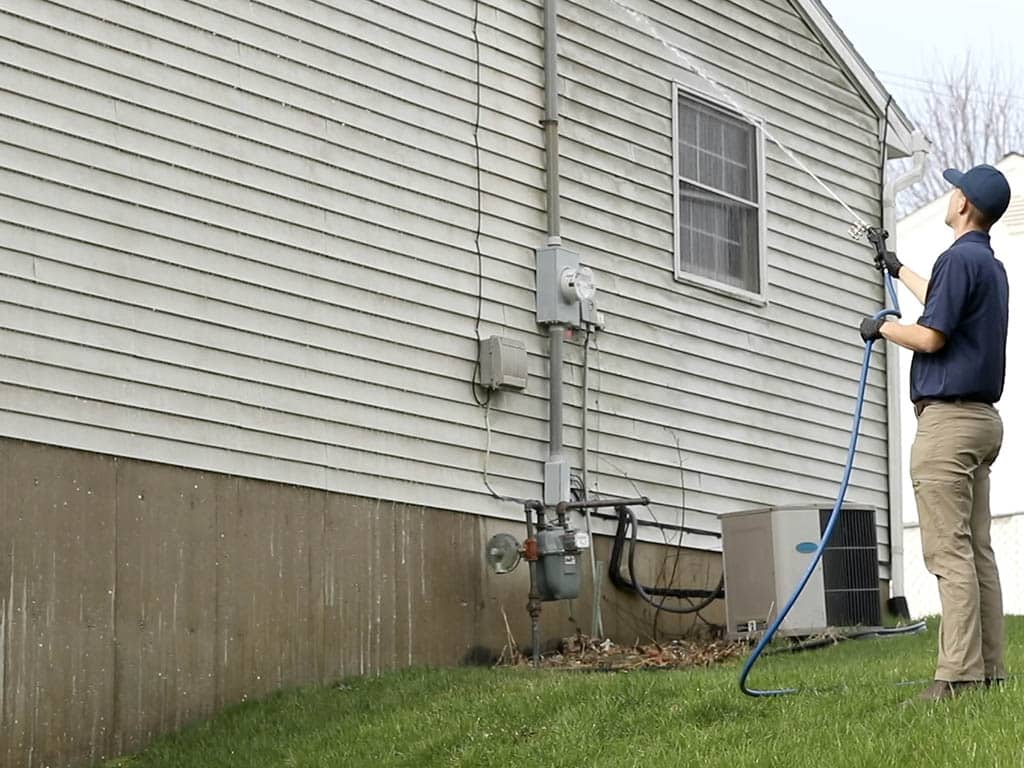 Man uses soft washing on dirty cladding