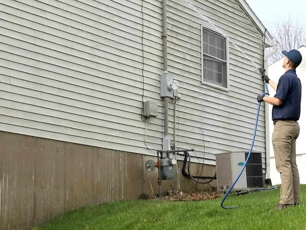Man uses soft washing on dirty cladding
